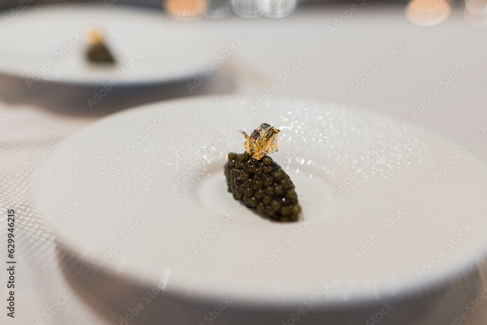 Focused photo of a caviar dish with gold leaf in a gastronomic restaurant. Focused photo of a caviar dish with gold leaf in a gastronomic restaurant.