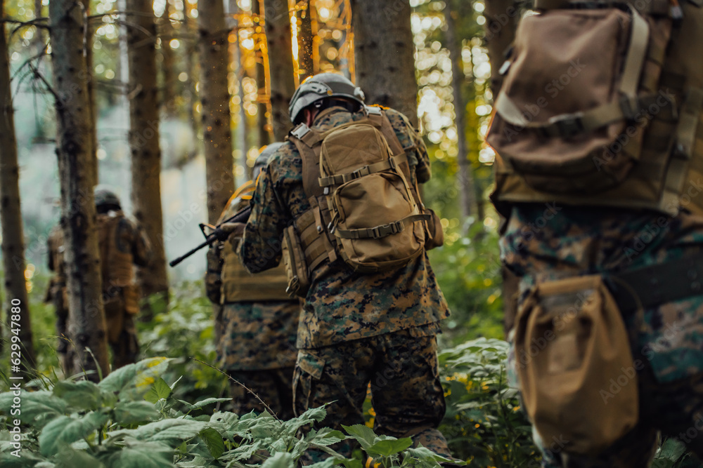 Fototapeta premium A group of modern warfare soldiers is fighting a war in dangerous remote forest areas. A group of soldiers is fighting on the enemy line with modern weapons. The concept of warfare and military