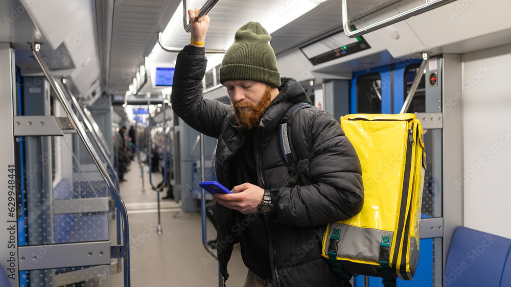 custom made wallpaper toronto digitalPanoramic photo. A male courier rides with a yellow thermos bag in the subway fulfilling a customer's order