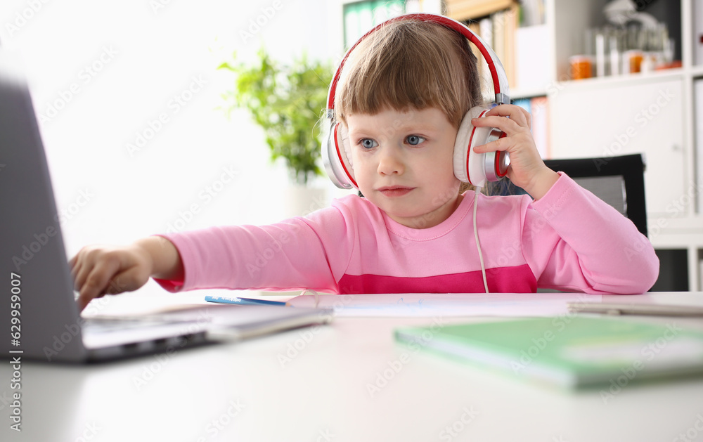 Child study at home with laptop and headphones. Distance learning concept and child watching cartoons Child study at home with laptop and headphones. Distance learning concept and child watching cartoons