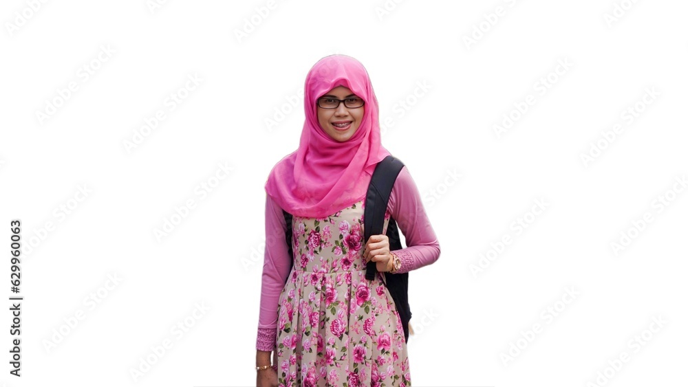 Close up portrait of young Muslim woman wearing pink hijab and dress with red rose flower motif and eyeglasses holding black backpack strap. Smiling and happy expression. Close up portrait of young Muslim woman wearing pink hijab and dress with red rose flower motif and eyeglasses holding black backpack strap. Smiling and happy expression.