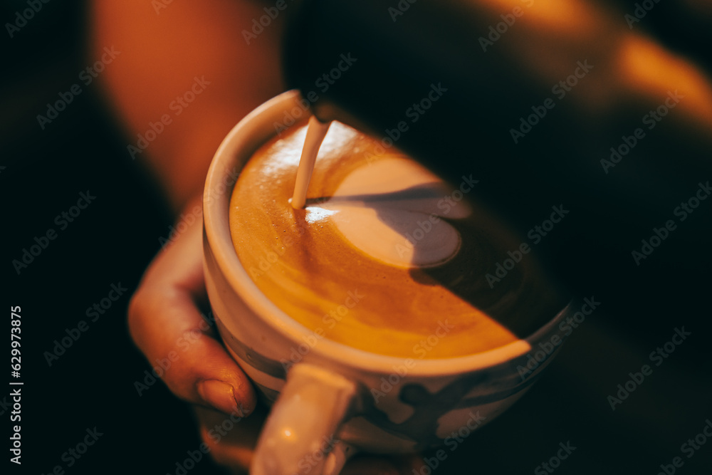 vintage tone of some people pour milk to making latte art coffee at cafe or coffee shop, barista making latte art, shot focus in cup of milk and coffee, vintage filter image