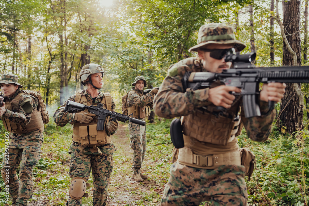 Fototapeta premium A group of modern warfare soldiers is fighting a war in dangerous remote forest areas. A group of soldiers is fighting on the enemy line with modern weapons. The concept of warfare and military