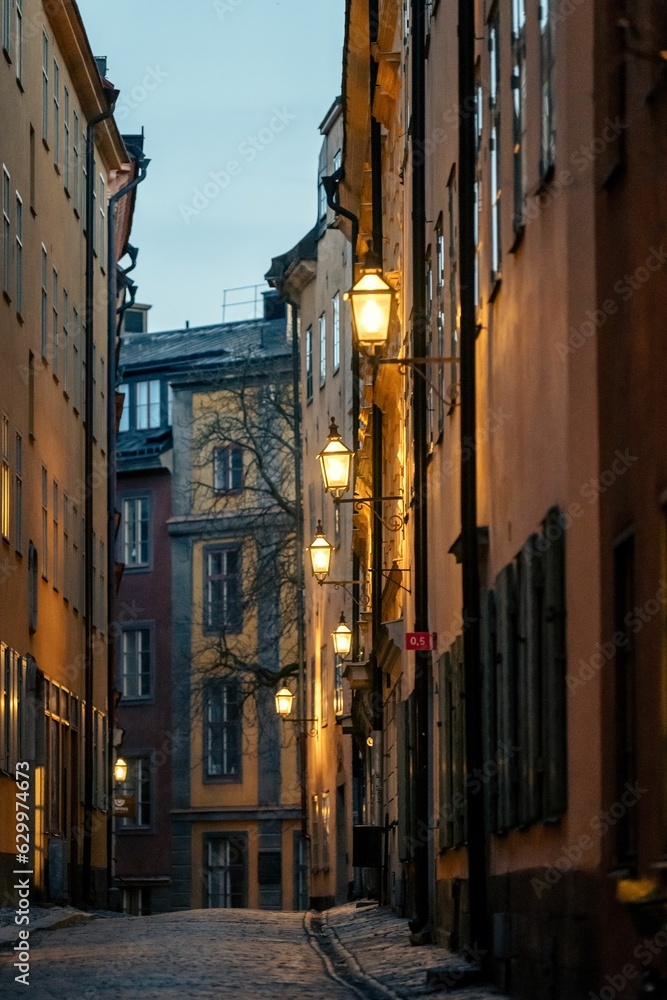 Picturesque cobblestone street illuminated by street lamps. Gamla stan, Stockholm, Sweden.