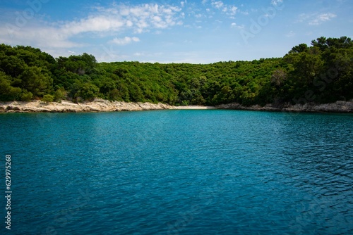 Stunning shot of a tranquil blue and green body of water during the bright mid-day sun