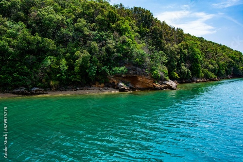 Stunning shot of a tranquil blue and green body of water during the bright mid-day sun