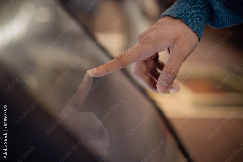 a person uses an interactive  touchscreen display of an electronic kiosk at an exhibition or in a museum - scrolling, touch gesture. Education, technology concept