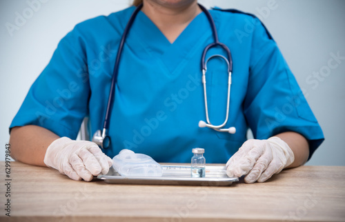 Medicine doctor is filling the medical syringe. Physicain is dawing medicine solution for her patient in emergengy room at the hospital. photo