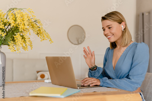 young pretty stylish woman working remote at home at table workplace, student education