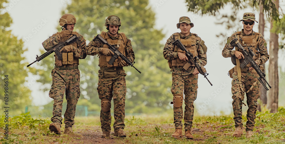 Soldier fighters standing together with guns. Group portrait of US army elite members, private military company servicemen, anti terrorist squad Soldier fighters standing together with guns. Group portrait of US army elite members, private military company servicemen, anti terrorist squad