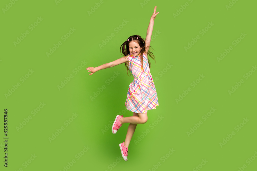 Full length photo of cheerful crazy energetic girl dressed trendy clothes rejoice seasonal offer isolated on green color background Full length photo of cheerful crazy energetic girl dressed trendy clothes rejoice seasonal offer isolated on green color background