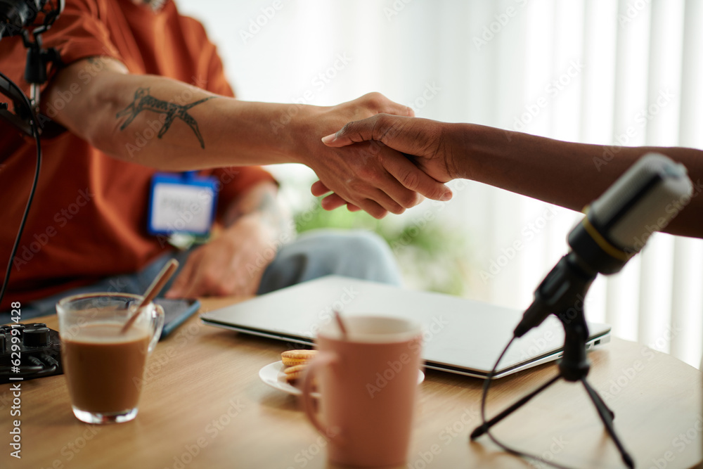 Podcaster and guest shaking hands before starting to record