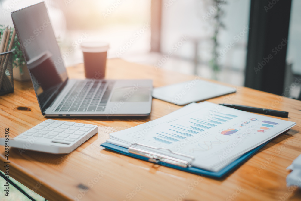 Office workplace with laptop and business paper on wooden table with copy space.. Office workplace with laptop and business paper on wooden table with copy space..