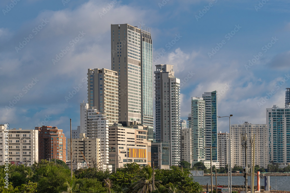 City skyline with many tall highrise office, business and condo skyscrapers at the waterfront by ocean, shot on a sunny day from Old City Fort walls, Cartagena Colombia. City skyline with many tall highrise office, business and condo skyscrapers at the waterfront by ocean, shot on a sunny day from Old City Fort walls, Cartagena Colombia.
