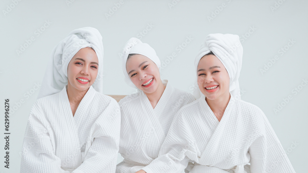 Portrait of women in bathrobes in white bedroom happily. Portrait of women in bathrobes in white bedroom happily.