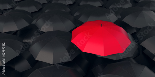 Red umbrella stand out from the crowd of many black umbrellas. Individual thinking concept.