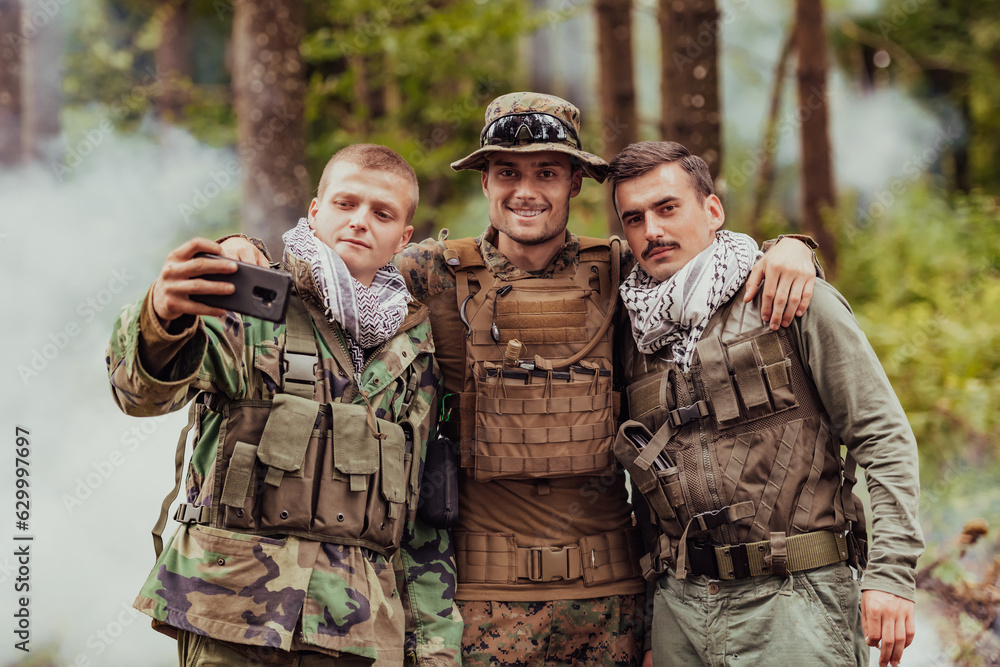 Fototapeta premium Team of soldiers and terrorist taking selfie with smartphone in the forest