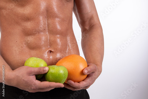 Sports, healthy eating and a healthy lifestyle. Young attractive man on a diet. Athletic handsome guy posing with sports nutrition in the studio.