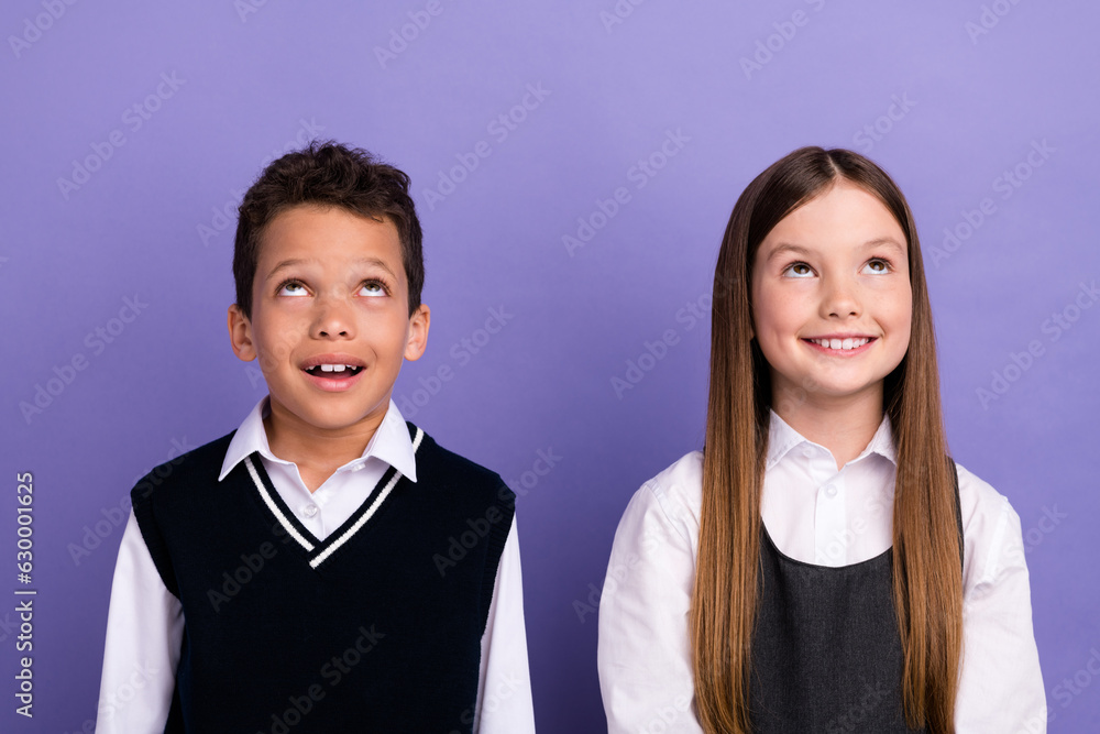 Photo of adorable kids elementary school pupils look up empty space sale discounts isolated bright color background Photo of adorable kids elementary school pupils look up empty space sale discounts isolated bright color background