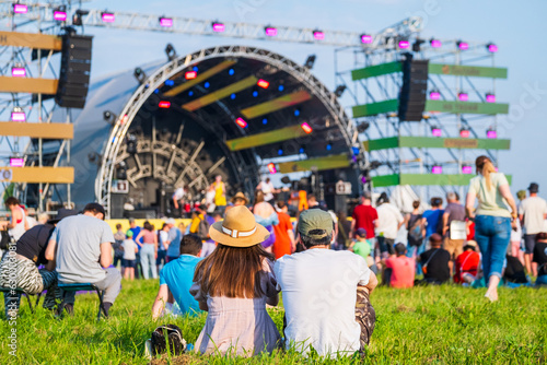 Crowd in front of stage at music concert on sunny day photo