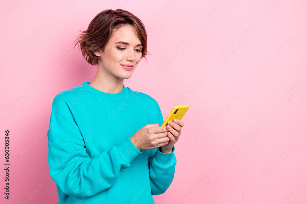 Portrait of nice positive lady hold use smart phone texting typing post empty space ad isolated on pink color background Portrait of nice positive lady hold use smart phone texting typing post empty space ad isolated on pink color background