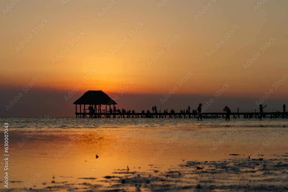 Punta Coco sunset wooden deck pier leading into ocean. In Holbox Quintana Roo Mexico.
