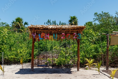 Sign of Yalahau lagoon with colorful letters and wooden swings. photo