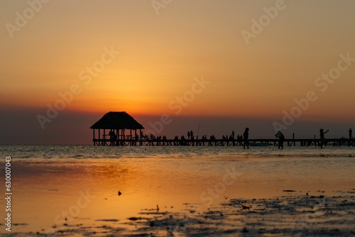 Punta Coco sunset wooden deck pier leading into ocean. In Holbox Quintana Roo Mexico.