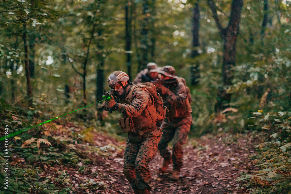 A group of modern warfare soldiers is fighting a war in dangerous remote forest areas. A group of soldiers is fighting on the enemy line with modern weapons. The concept of warfare and military A group of modern warfare soldiers is fighting a war in dangerous remote forest areas. A group of soldiers is fighting on the enemy line with modern weapons. The concept of warfare and military