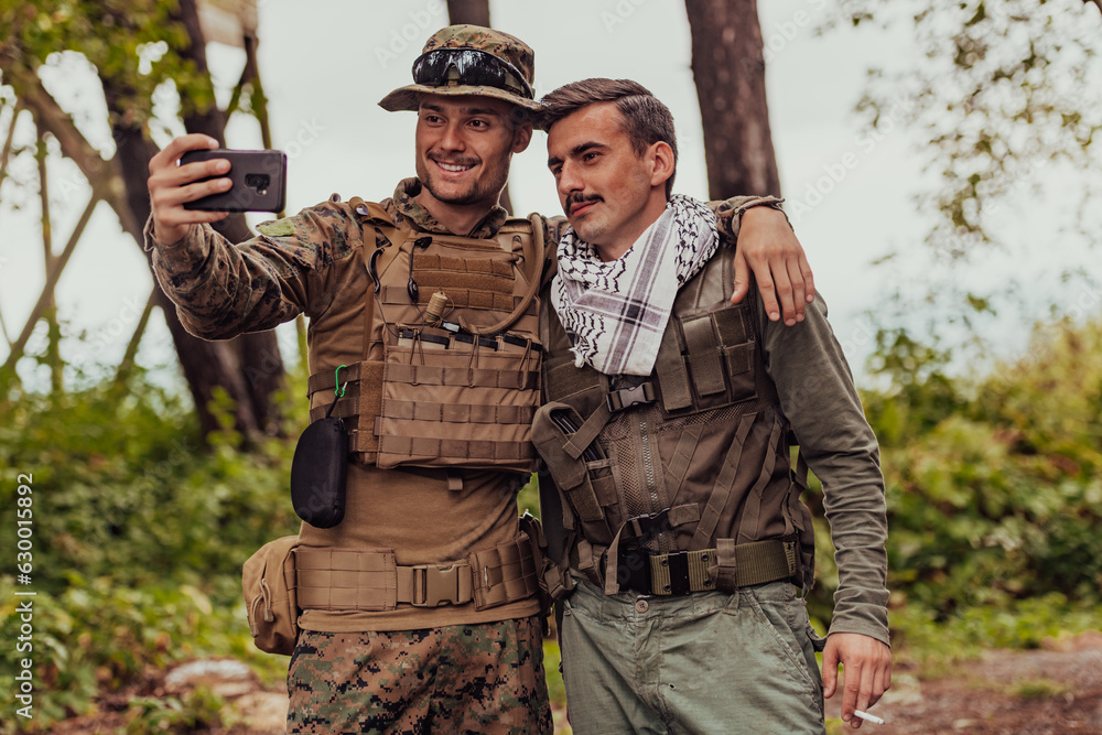 Team of soldiers and terrorist taking selfie with smartphone in the forest