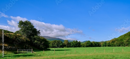 Landscape of hills covered in greenery under the sunlight and a blue cloudy sky