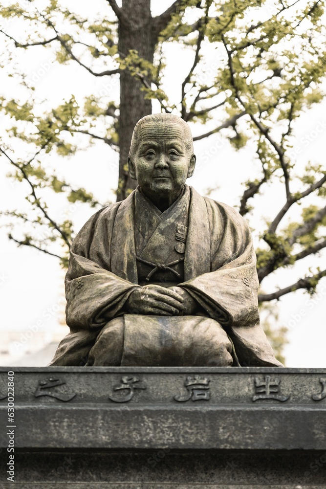 Japanese statue in a grassy field surrounded by trees Japanese statue in a grassy field surrounded by trees