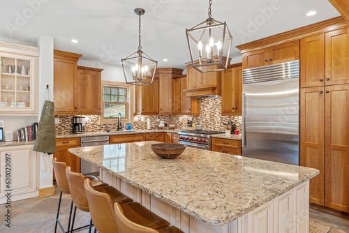 Obraz na plátne Modern kitchen with a granite island countertop and wooden cabinetry