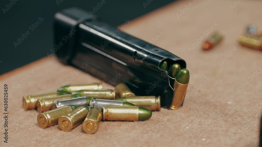 Semi-automatic 9mm pistol and bullets on wooden table indoors, closeup Semi-automatic 9mm pistol and bullets on wooden table indoors, closeup