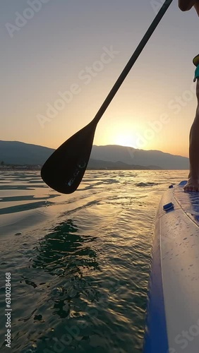 Man Riding Paddleboard On Sunset photo