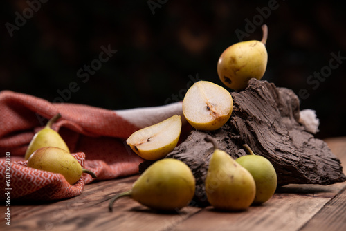 Juicy pear slice and pears on wooden table
