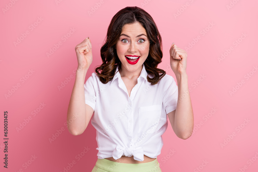 Photo of lucky sweet young girl dressed white top shouting rising fists isolated pink color background Photo of lucky sweet young girl dressed white top shouting rising fists isolated pink color background