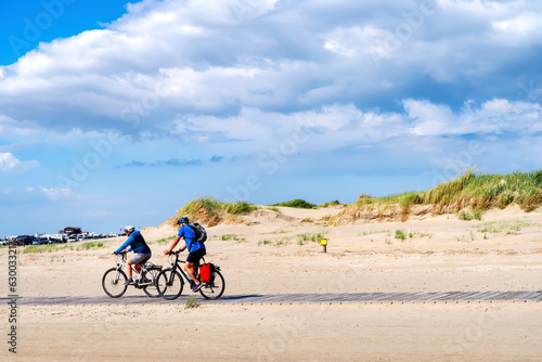 Fototapeta Naklejka Na Ścianę i Meble -  Cyclists on the beach of Sankt Peter Ording, North Sea, Germany
