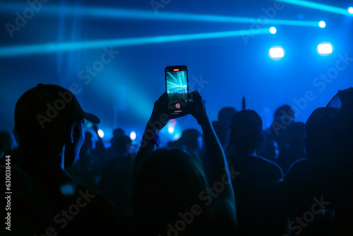 People holding smart phone and recording and photographing in concert , silhouette of hands with mobile , event background concept