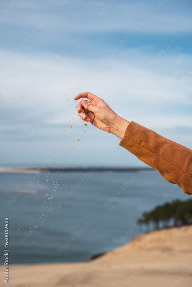 Dune sand sliding down a woman's hands