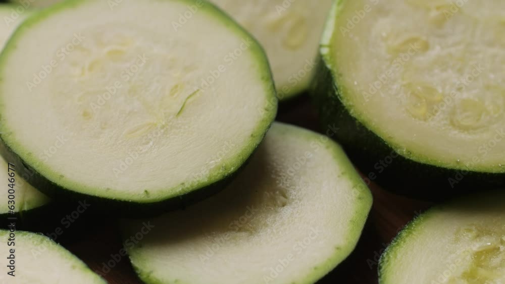 Chef cutting fresh zucchini on wooden board, close up macro of squash courgette. Chef cutting fresh zucchini on wooden board, close up macro of squash courgette.