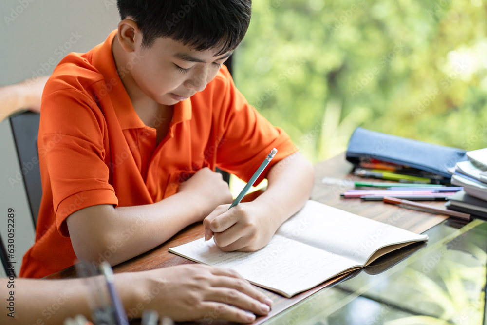 Asian father helps son to do her homework for the school..child study together homeschooling concept getting homework help from father Asian father helps son to do her homework for the school..child study together homeschooling concept getting homework help from father