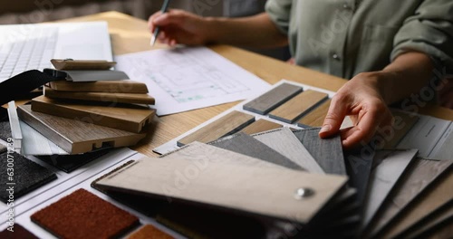 interior designer working on new house design project in office. choosing flooring and furniture materials and colors from samples