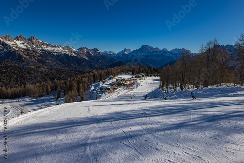 Beautiful alpine panoramic view of snowy mountains, beautiful European winter mountains in Italy Dolomites, lope for cross country skiers and downhill skiers in countryside. Picturesque wintry scene