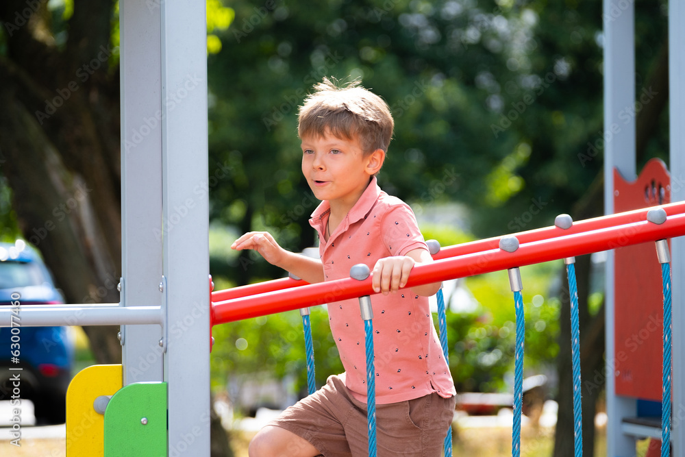 Obraz premium Portrait of six year old boy on playground in summer..
