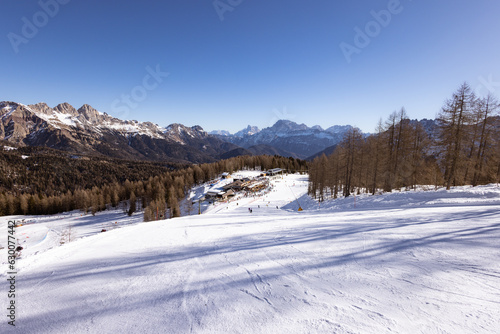 Beautiful alpine panoramic view of snowy mountains, beautiful European winter mountains in Italy Dolomites, lope for cross country skiers and downhill skiers in countryside. Picturesque wintry scene