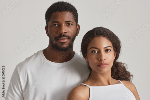 Minimal portrait of young black couple looking at camera against white background