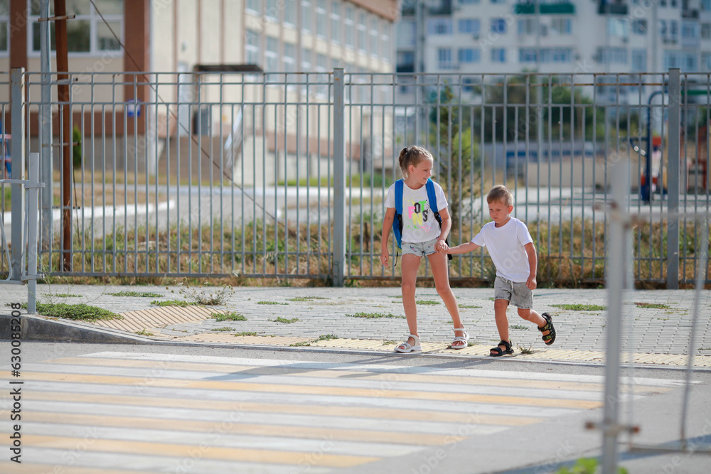Brother and sister run across a pedestrian crossing. Children Run along