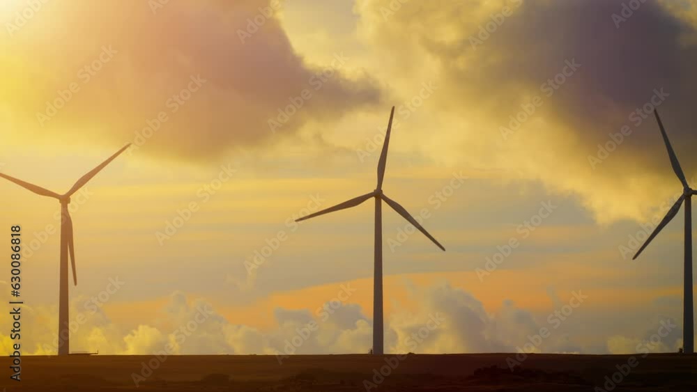 Row of wind turbines near the ocean in Hawaii at sunset