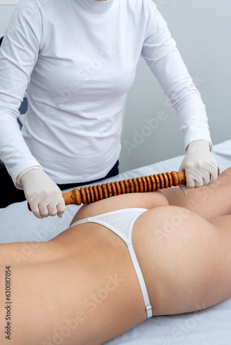 Body treatment in an aesthetic center with the technique of wood therapy for beauty, health and body care photo